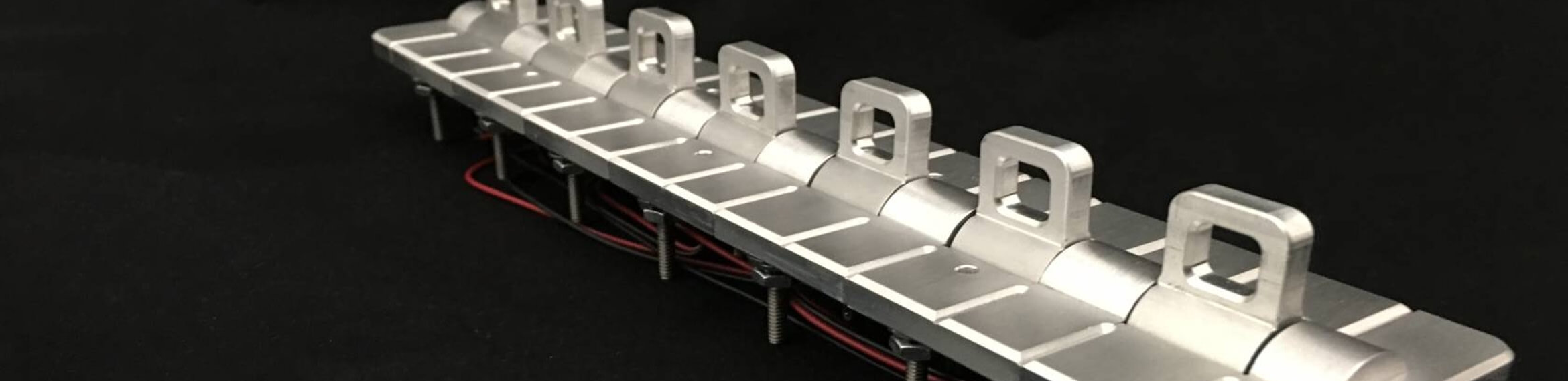 Billet aluminum hot rod switch panel assembly with multiple toggle switches and color-coded red and black wiring shown from isometric view